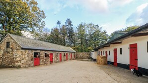 A stone building with red doors and a white building with red doors. - Robins Rest at The Lodge (Kilmacthomas)