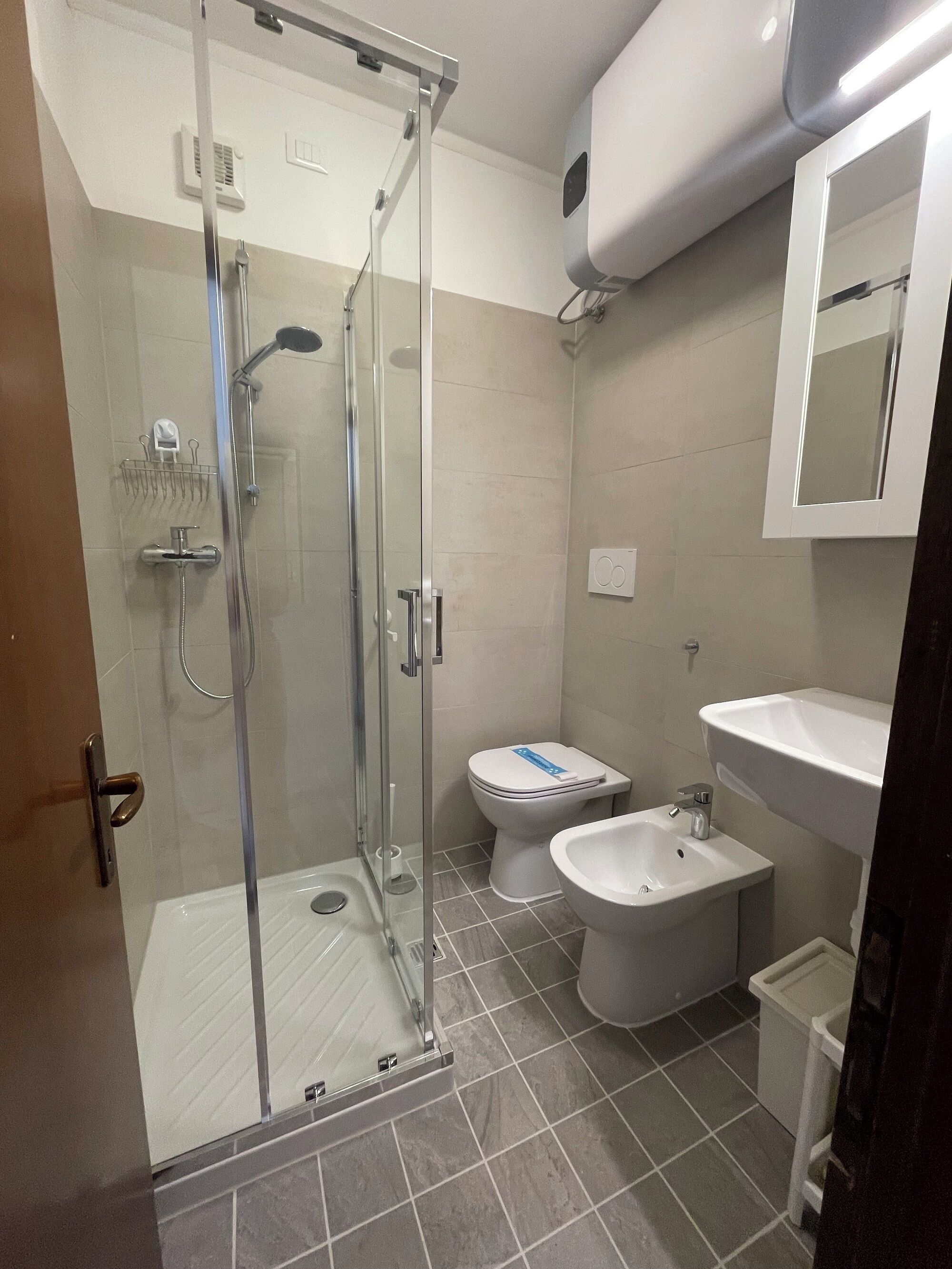 Une salle de bain moderne avec une douche à parois de verre, des toilettes, un bidet et un lavabo.