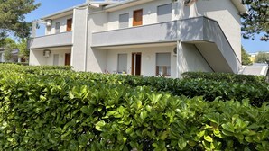 A two-story building with a modern architectural style, featuring a flat roof, satellite dish, and a chimney. - Bibione Apartment With Pool Access (San Michele al Tagliamento)