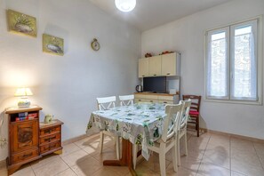 Un espace repas comprenant une table, des chaises, un buffet, une horloge et une fenêtre.