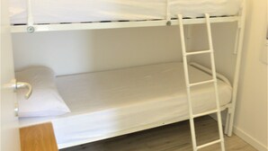 A bunk bed with a ladder, a wooden desk, and a light-colored floor. - Bright Flat With Pool and Balcony (San Michele al Tagliamento)