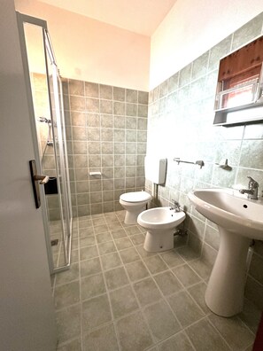 A bathroom with two toilets, a bidet, and a sink. - Cozy Flat in a House With Pools (San Michele al Tagliamento)