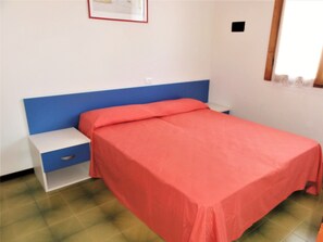 A bedroom with a single bed, a nightstand, and a small drawer unit. - Comfy Apartment With Pool-beahost (San Michele al Tagliamento)