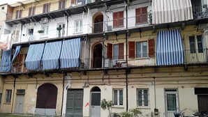 Un edificio a più piani con balconi, piante in vaso e biciclette.