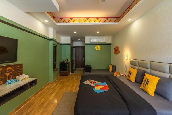 A hotel room with a bed, a TV, a desk, and a wall clock. - The Hosteller Mcleodganj, Bhagsu Waterfall (Dharamshala)