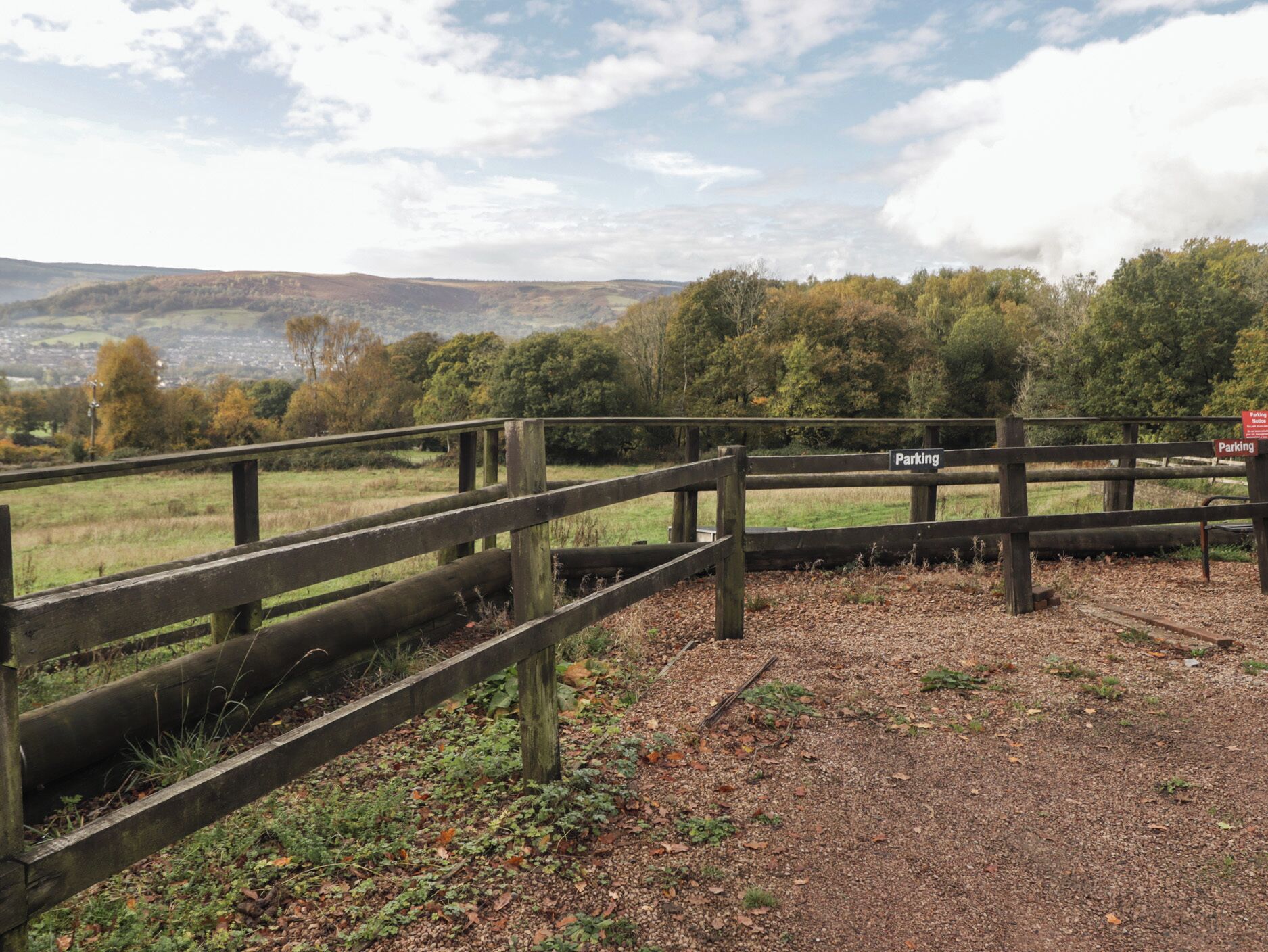 A wooden fence with a sign indicating a parking area.
