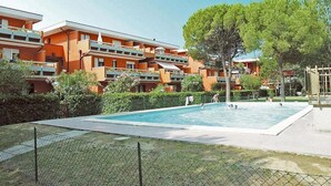 A residential building with a swimming pool surrounded by greenery. - Apartment With Pool Access Near Beach (San Michele al Tagliamento)