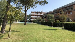 A residential building with multiple balconies, a swimming pool, and well-maintained lawns. - Apartment With Pool Access Near Beach (San Michele al Tagliamento)