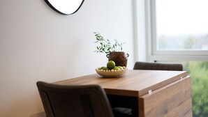 A dining table with a bowl of fruit and a potted plant. - Streatham Hill Modern Flat with Balcony (London)