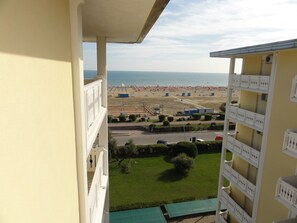 Un balcone con vista sulla spiaggia e su un'area parcheggio.