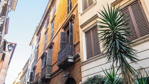 A narrow street with buildings featuring balconies and shutters. - Rental in Rome Navona Loft (Rome)
