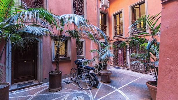 A courtyard with a bicycle, potted plants, and a tiled floor. - Rental in Rome Navona Loft (Rome)