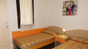 A room with two beds, a nightstand, and a wall-mounted picture. - Townhouse With Private Garden (San Michele al Tagliamento)