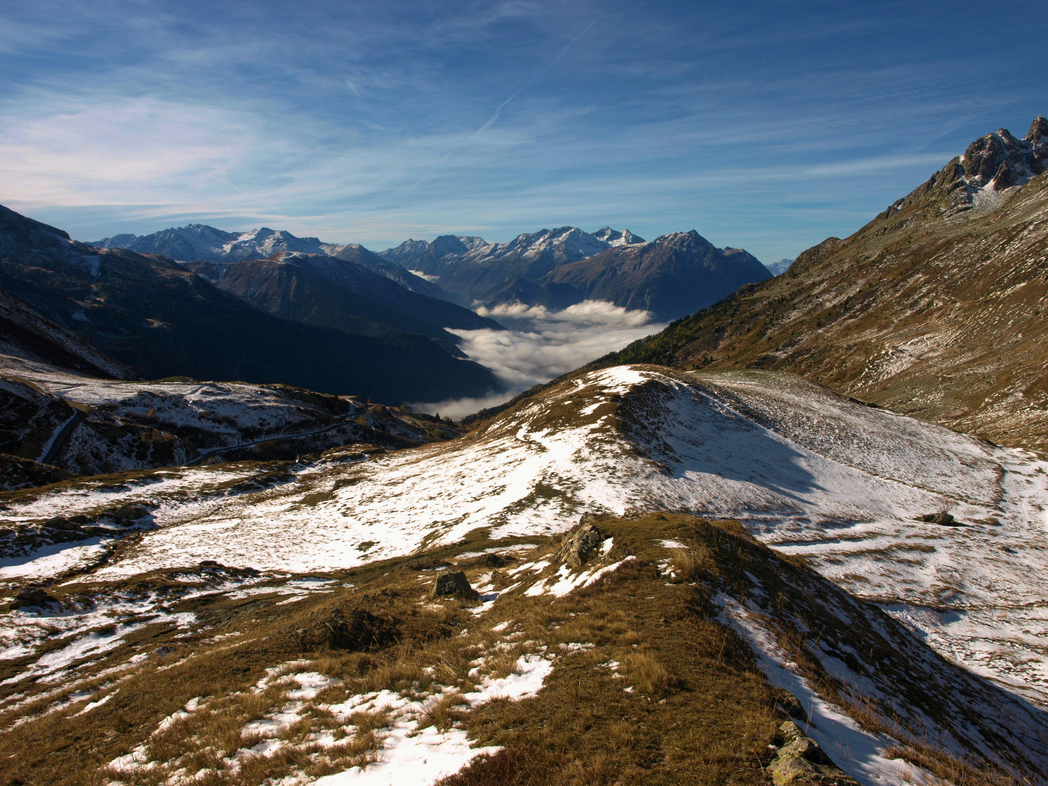 A mountainous landscape with snow-covered slopes and a valley.