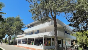 A two-story building with a balcony and a covered outdoor seating area.