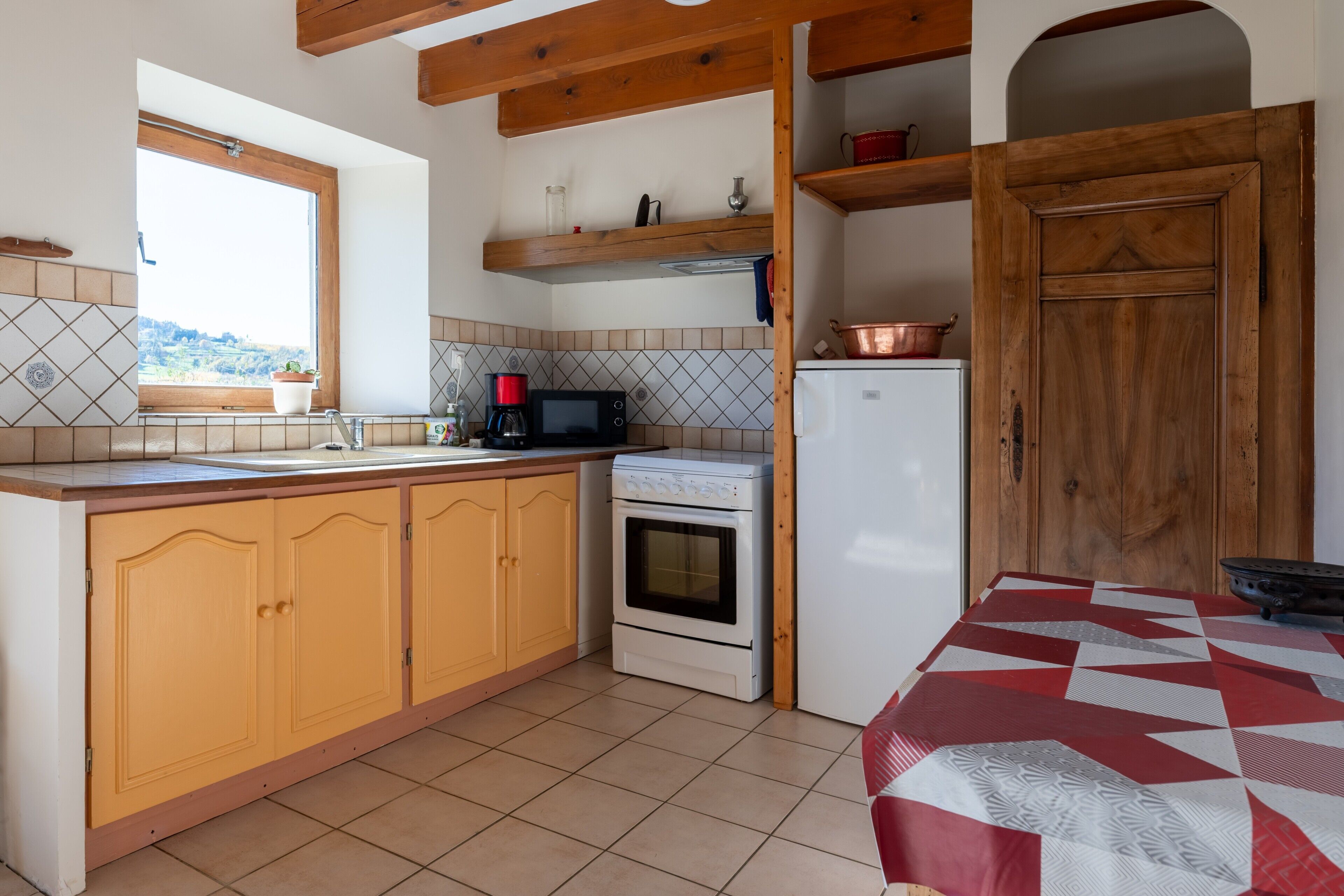 A kitchen with wooden cabinets, a stove, a microwave, and a refrigerator.