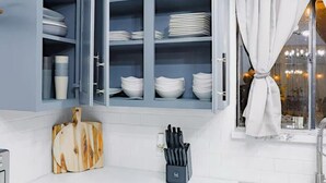 A kitchen with blue cabinets, a cutting board, and a knife block. - VillaVerde 4BRs/Pool/Sleeps16/Gym/Gameroom/HTX/NRG (Houston)