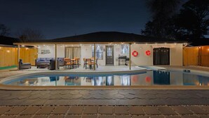 A backyard with a swimming pool, outdoor furniture, and a covered patio area. - VillaVerde 4BRs/Pool/Sleeps16/Gym/Gameroom/HTX/NRG (Houston)