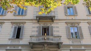 A building with a central balcony, multiple windows with shutters, and a large wooden door. - Da Laura e Guido by Wonderful Italy (Turin)