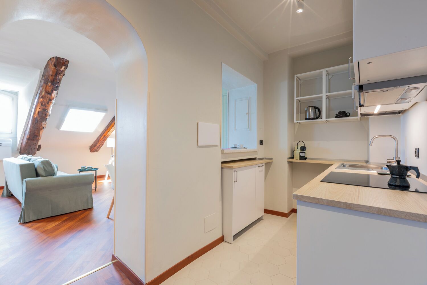 A modern apartment with a loft-style living area, a compact kitchen with integrated appliances, and a small dining area.