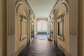 Un vaste hall d’entrée orné de colonnes décoratives et surmonté d’une grande fenêtre en arc de cercle.