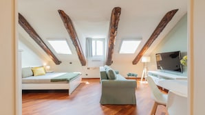 A loft-style bedroom with a bed, sofa, desk, and TV. - Da Laura e Guido by Wonderful Italy (Turin)