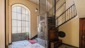 A staircase with a metal railing, a wooden bench, and a patterned floor. - Da Laura e Guido by Wonderful Italy (Turin)