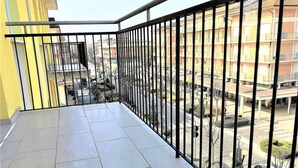 A balcony with a tiled floor and a metal railing. - Bibione Central Apartment (San Michele al Tagliamento)