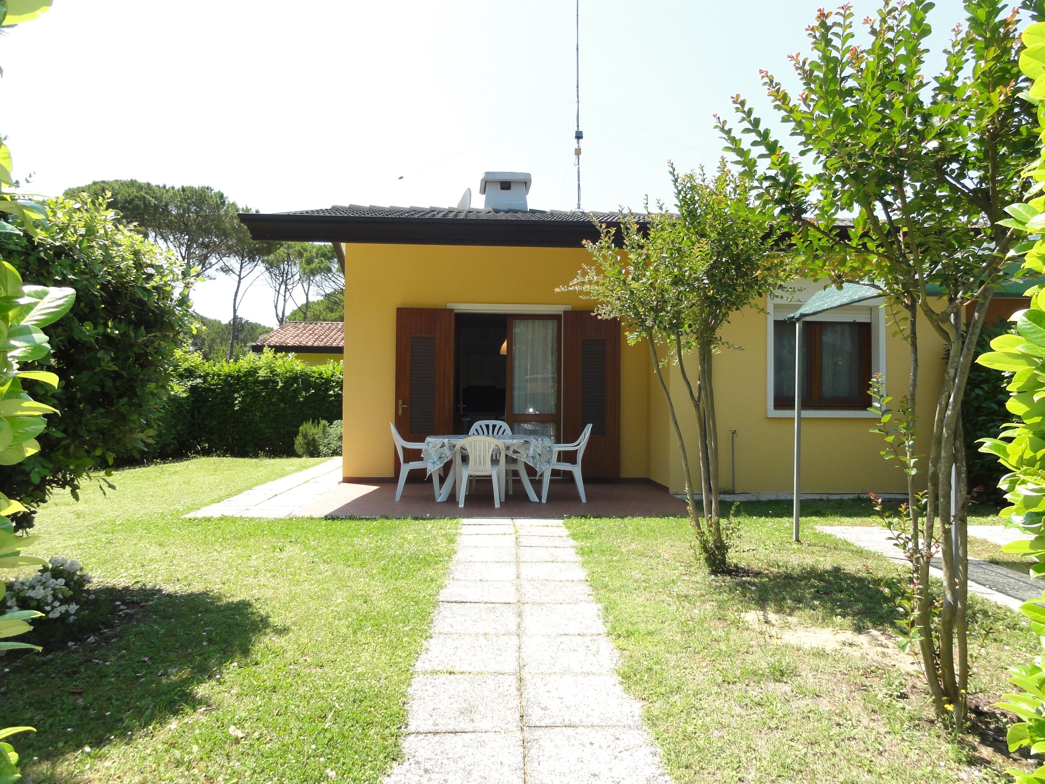 A yellow building with a patio area featuring a table and chairs.