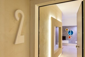 A hallway with a large number '2' on the wall, a door leading to a room with a modern design, and a wall with circular decorative elements.