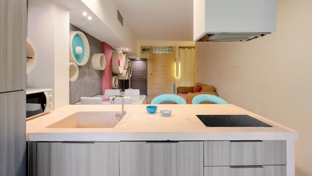 A modern kitchen with a central island, built-in appliances, and a seating area with blue chairs. - Apartment 'Biancomare Otranto - Apt 2' with Balcony, Wi-Fi and Air Conditioning (otranto)