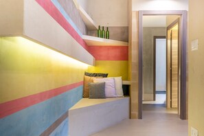 Una scala con pareti dipinte di colori vivaci e una panca con cuscini.