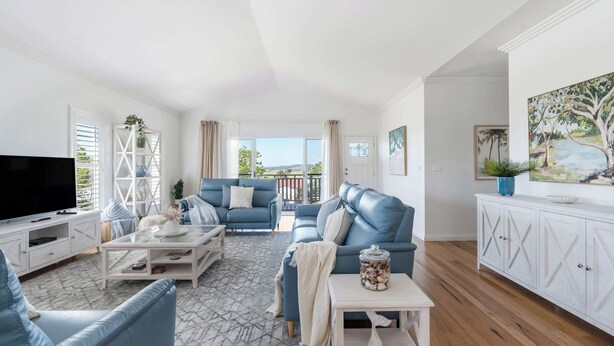 A living room with a TV, sofas, a coffee table, and a view of the outdoors.
