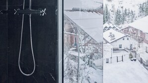 A bathroom with a glass shower enclosure and a view of a snowy mountain landscape. - Chalet Ischgl - Modern Luxury Residences (Ischgl)