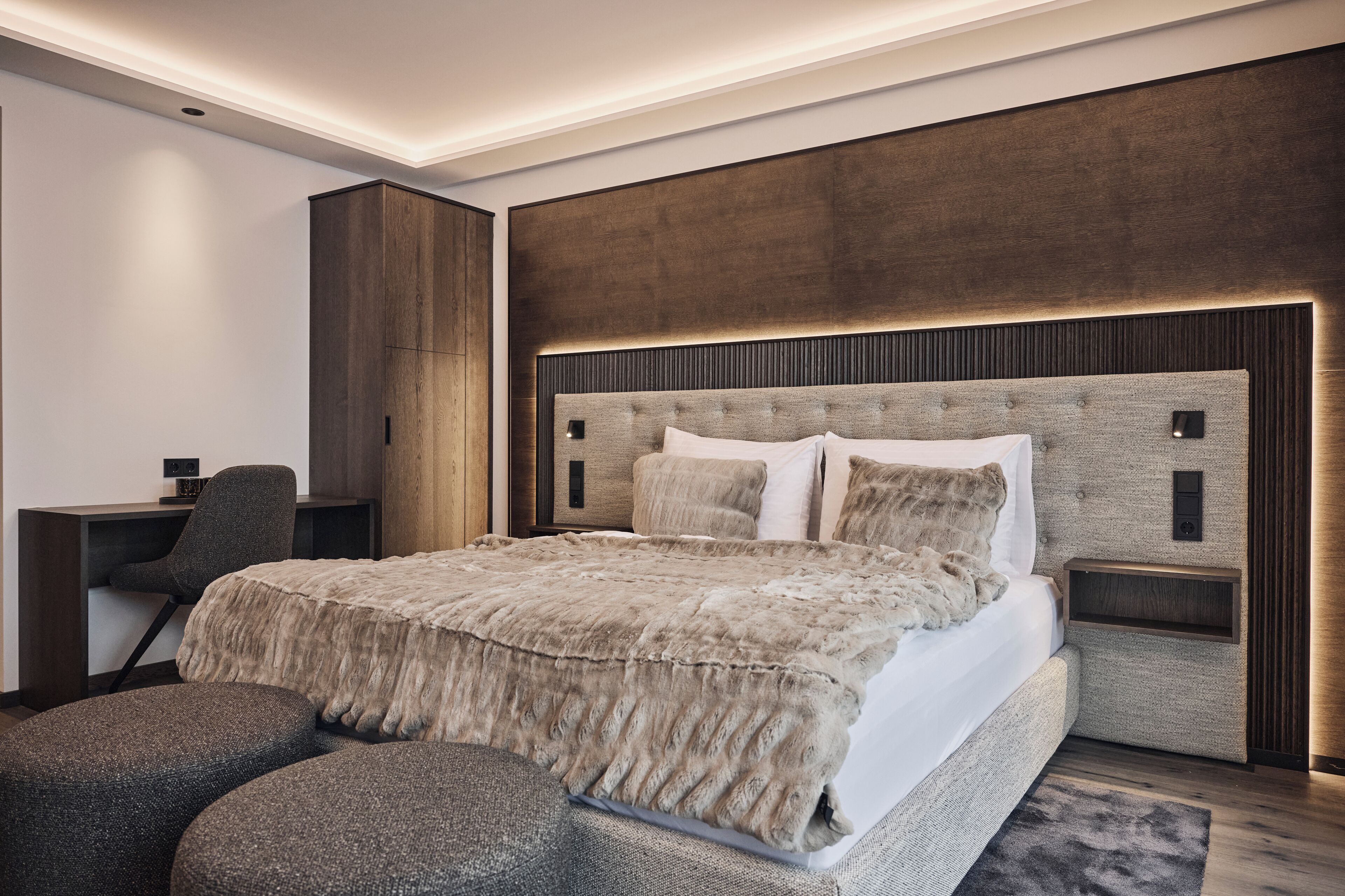 Un dormitorio moderno con una cama grande, un escritorio y una silla.