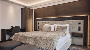 Un dormitorio moderno con una cama grande, un escritorio y una silla.