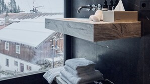 A modern bathroom with a large window, a marble countertop, and a view of a snowy mountain. - Chalet Ischgl - Modern Luxury Residences (Ischgl)