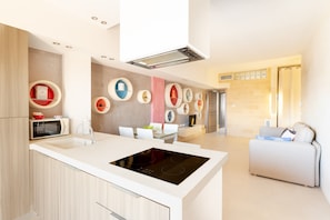 A modern kitchen with a central island, built-in appliances, and a dining area with a white table and chairs. - Apartment 'Biancomare Otranto - 6' with Balcony, Wi-Fi and Air Conditioning (otranto)