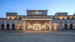 Ein luxuriöses Resort mit einem imposanten Eingang, mehreren Bögen und einer gut beleuchteten Fassade.