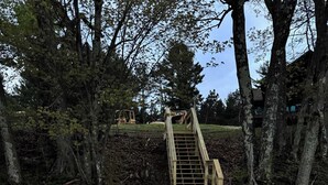 Une jetée en bois s’étendant dans une étendue d’eau, entourée d’arbres.