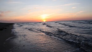 Uma praia com ondas ao pôr do sol.