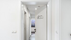 Um corredor com uma porta, um logotipo e um interruptor de luz.