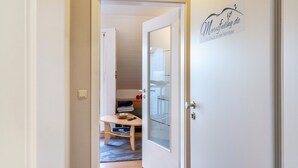 A room with a bed, a bedside table, a chair, and a window. - Meeresfeeling for 2: Cozy North Sea Apartment, 34 sqm, 1 Bedroom, Max 2 Guests (Horumersiel)