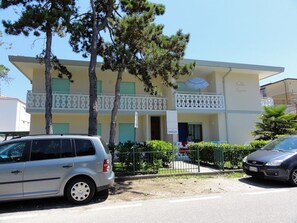 Un bâtiment à deux étages doté d’un balcon, d’une enseigne indiquant « LIVENZA » et d’une voiture garée devant.