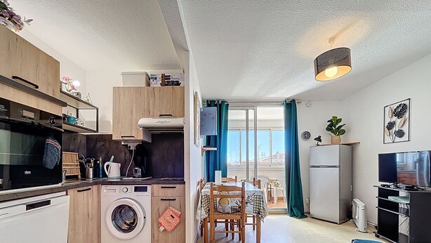 A compact living space with a kitchen, dining area, and a small balcony. - Bright apartment near beach (Narbonne)