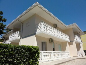 Een gebouw met twee verdiepingen, een balkon, een deur en een raam.