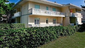 A two-story building with balconies, a flat roof, and a garden in front. - Apartment Close to the Thermal Baths (San Michele al Tagliamento)