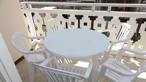 A round white table with four white plastic chairs, surrounded by a white metal fence with cut-out designs. - Apartment Close to the Thermal Baths (San Michele al Tagliamento)