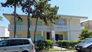 A two-story building with a balcony, a sign indicating 'LIVENZA', and a parked car in front. - Apartment Close to the Thermal Baths (San Michele al Tagliamento)