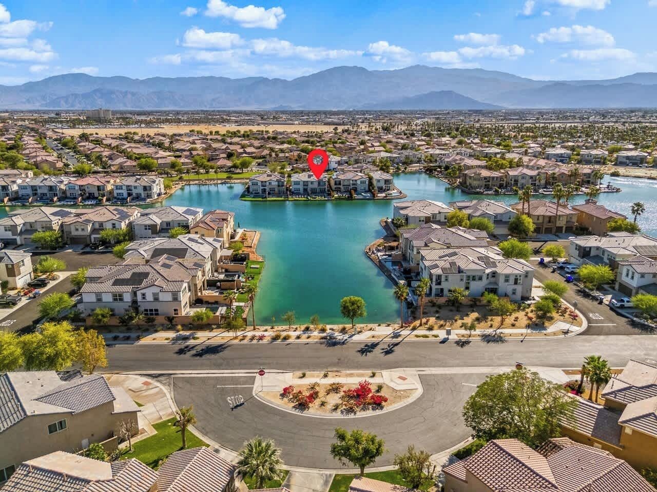 A residential area with houses, a roundabout, and a lake.